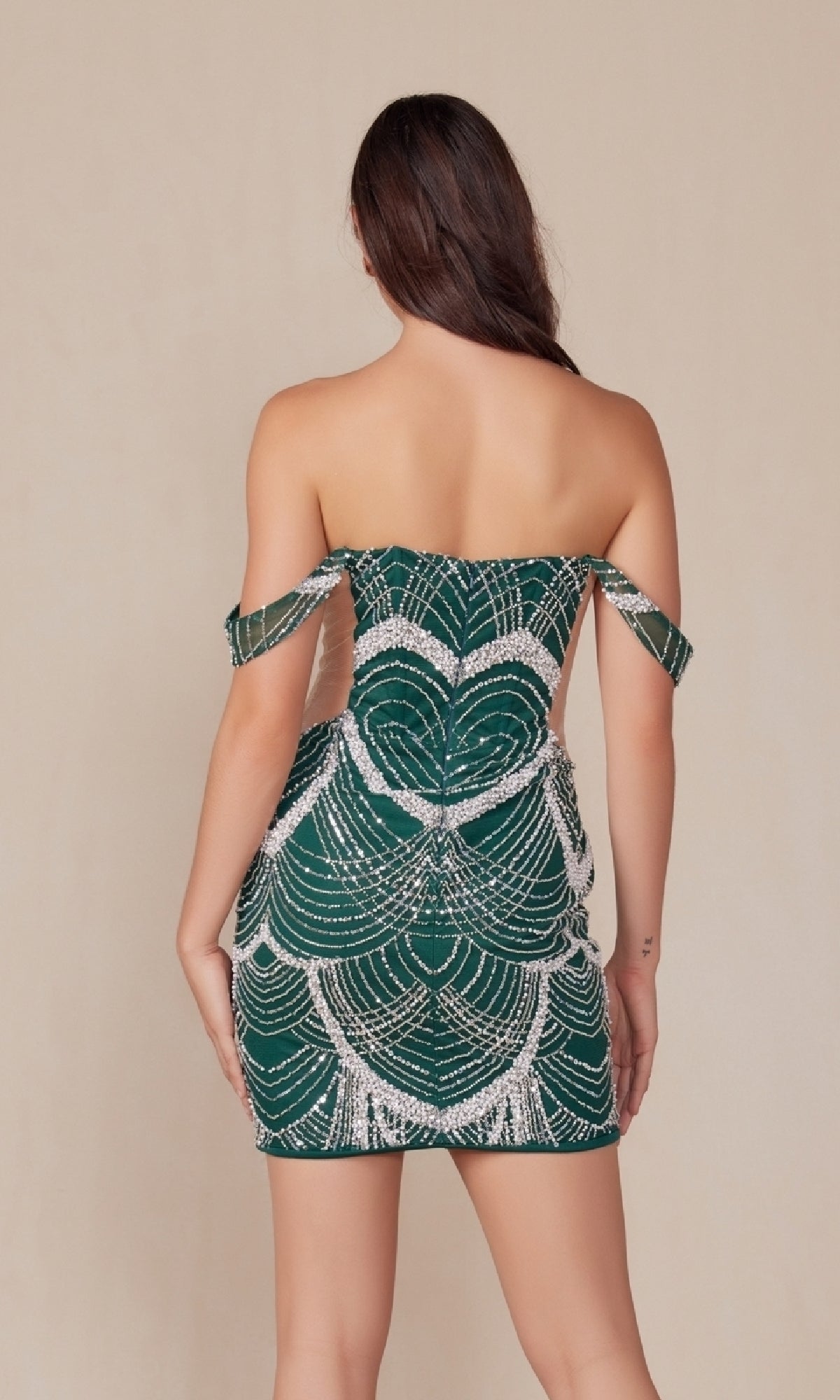 A woman faces away, wearing the Sheer-Sides Short Sexy Homecoming Dress Q839 in green, featuring an off-the-shoulder design with a short silhouette and white sequin scallop patterns.